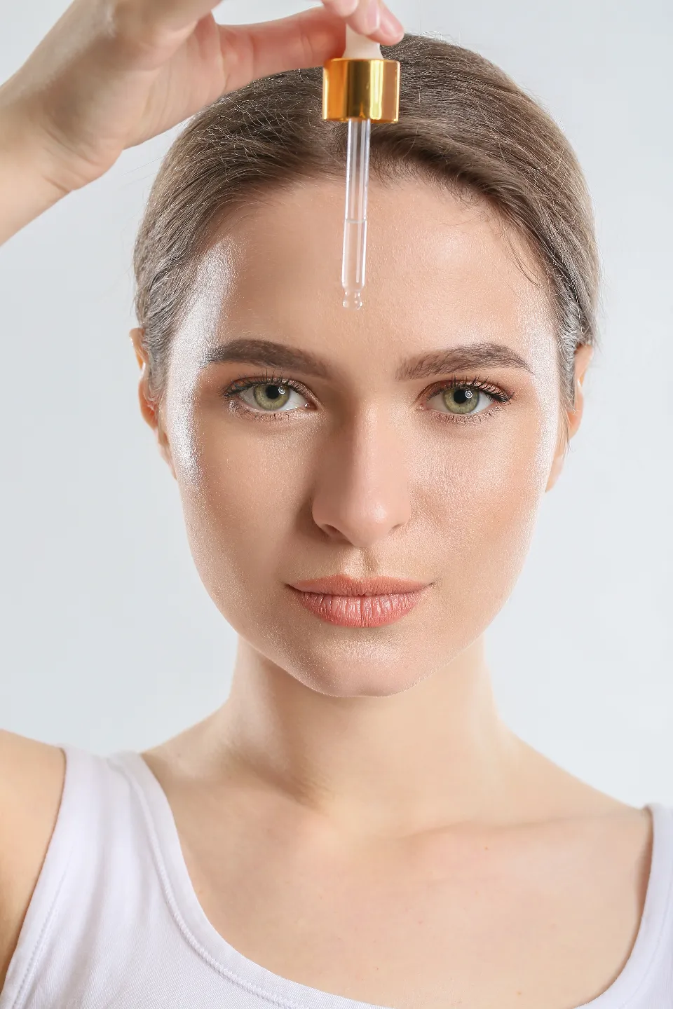 Close-up of a skincare serum being applied to glowing skin